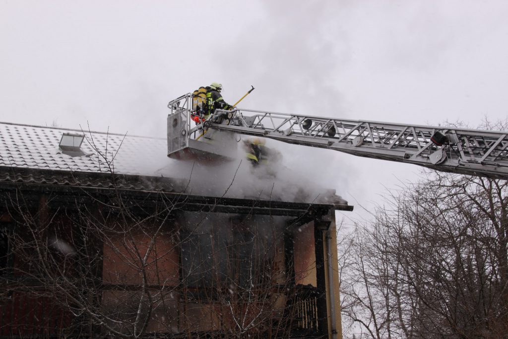 Brandbekämpfung: An der Dachkante werden die Dachplatten abgenommen und die Balken abgelöscht. Foto FF Neubiberg 